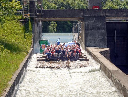 Floss mit jubelnder Gruppe schiesst die grosse Flossrutsche im M&uuml;hltal hinunter