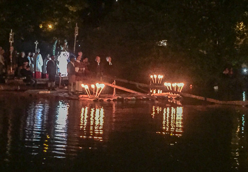 Nächtliche Fackelprozession mit beleuchteten Flößen auf der Loisach