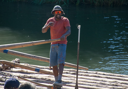 Flößer Jason steuert das Floss mit Ruder auf der Isar