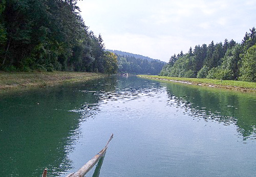 Blick vom Floss auf den ruhigen Flosskanal mit Wald an beiden Ufern